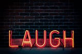 A big neon sign that says “LAUGH”