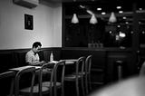 Man sitting by himself in a coffee shop.