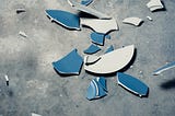 pieces of a broken plate spread on the floor