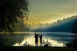 Taking a break. Two boys with bicycles on the lake.