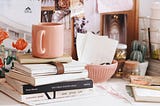 Coffee Cup sitting on books and journals on a desk. Story: I am a Writer by Rena Willis