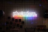 A rainbow-colored neon signage of the Photodom logo