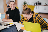 Man and woman sitting and laughing at a desk