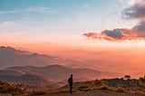 Hiker on a background of mountaintops — peaceful