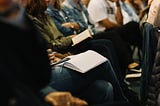 People sitting in the audience at a political meeting