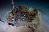 The Saturn V F-1 engine sitting half-buried on the ocean floor