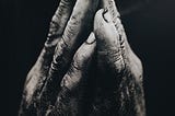 a black and white photo of hands together in prayer
