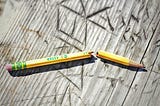 Broken pencil on a wooden surface
