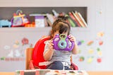 toddler holding up toy camera to the real camera