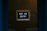 “Not An Entry” posted on a dark door.