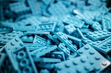 Bluewashed image of assorted Lego pieces.