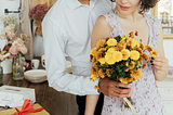 A man giving a lady a bouquet of yellow chrysanthemums as Valentine’s Day flowers.