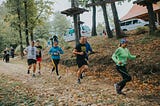 People running in the woods.