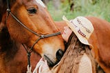 A woman cuddling a horse