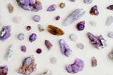Various-sized amethyst crystals laid out on a surface.