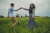 A couple dances in a summer meadow, representing the summer of love.