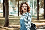 Beautiful contemplative female walking in woods