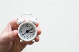 Small clock held in a person’s hand