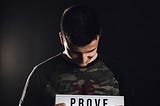 a man showing paper saying Prove them wrong.