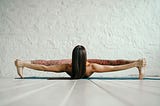 A woman doing an extreme yoga pose on a mat