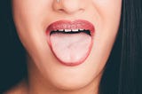 a lady sticking out her light pink tongue