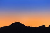 Orange sunset with a silhouette of dark mountains in the foreground