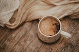 Coffee with cream on rustic wooden table net to cloths. To unplug, or not to unplug. That is the question. Should we unplug from technology.