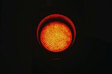 A red stoplight in a dark background