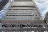 A skyscraper with “The New York Times” projected onto it.