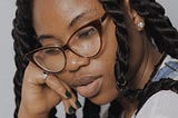 a black moody girl with glasses on