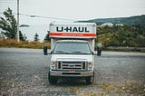 A U-Haul truck off the side of a highway facing the viewer.