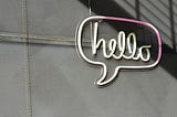 Neon sign of the word hello in a speech bubble.