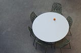 A round table, with an orange on it for some reason.