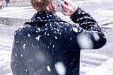 Person holding their phone in snow