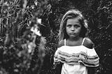 Black & white photo of a sad little girl.