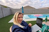 Woman working on a computer by the pool