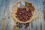 A basket of chestnuts with leaves and a ceramic heart