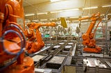 robot arms performing production tasks in a factory setting