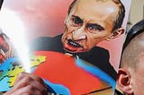 A caricature of Putin grabbing a bloodstained Ukraine