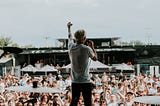 Rock band “The World Alive” performing for fans at a festival.