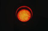 A red light from a traffic sign, indicating to stop.
