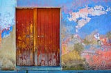 A red door on a colorful wall