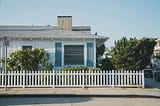 One story home with white picket fence