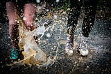 Two women splashing in murky puddles