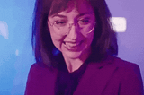 Gif: Woman wearing glasses laughing awkwardly and showing both thumbs. Overlaid text says, “No problem!”