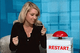 A girl that just realised she messed up, and press a big red Restart button