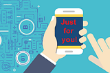 A smartphone displaying ‘Just for you!’ on its screen shown in a person’s hand.