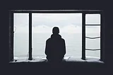 Sad man gazing out of window