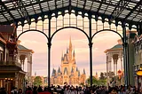 The famous Disney castle with a crowd of people in the foreground.