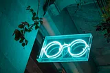 A white neon sign at night in the form of round spectacles.